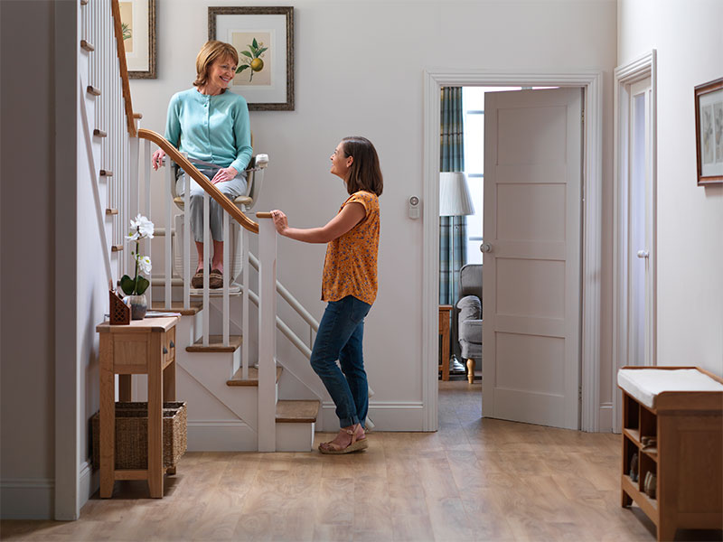 Uma mulher idosa se prepara para a aposentadoria e sua casa com uma cadeira elevatória