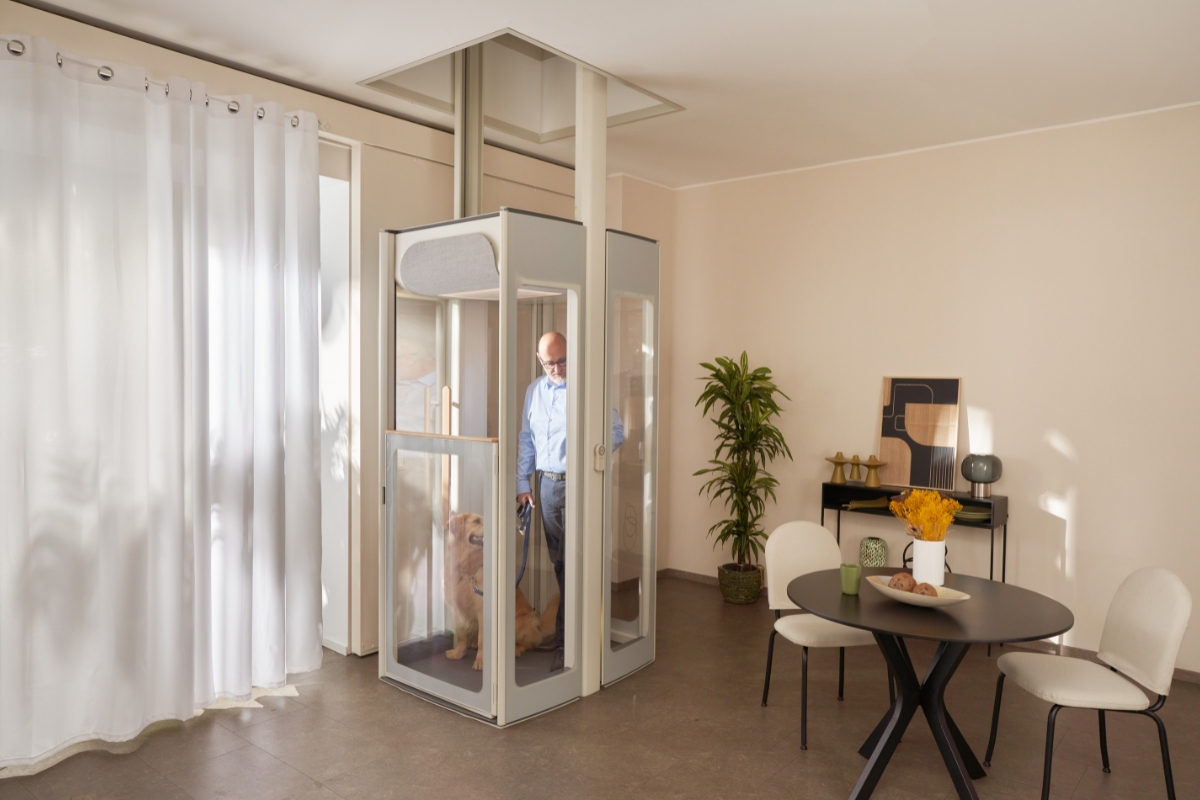 Homem de meia-idade com o seu cão no elevador residencial Uplifts da Stannah.